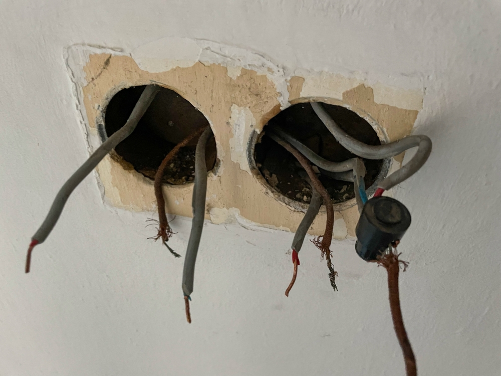 Close,Up:,Wall,Cutout,Reveals,Exposed,Electrical,Wiring,With,Frayed